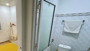 A bathroom with a toilet, sink, and towel rack. - Enjoy Homestay  (Ho Chi Minh City)