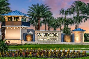A resort with a sign reading 'Windsor Island Resort,' surrounded by palm trees and a well-maintained lawn.