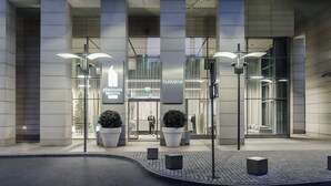 A modern building with large glass windows and a sign for 'Platinum Towers'. - Lumina platinium Tower Apartments (Warsaw)