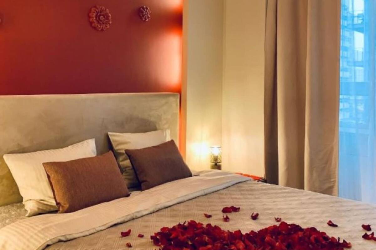 Quarto de hotel com uma cama grande, parede decorativa e luminária pendente.