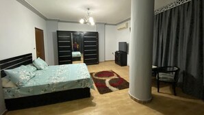 Un dormitori amb llit, armari, escriptori i cadira.