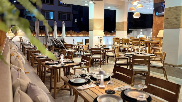 A restaurant with multiple dining tables and chairs, some with umbrellas. - Oji Boutique Hotel (Alanya)