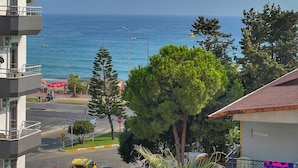 A coastal view with a building overlooking the sea, a street with a taxi, and a sign for 'Gazi Pazapa'. - Oji Boutique Hotel (Alanya)