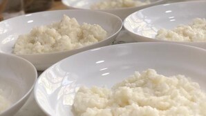 Des assiettes blanches contenant du riz, posées sur un comptoir en marbre.