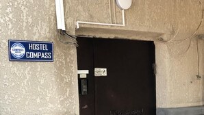 Une porte noire avec une enseigne au-dessus indiquant : « AUBERGE COMPASS ».
