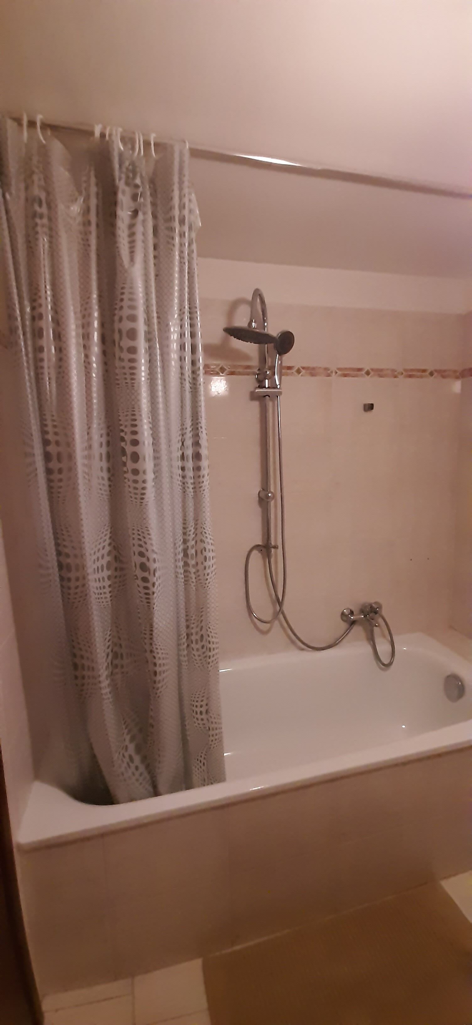 Une salle de bain avec une baignoire, une douche et un rideau de douche.