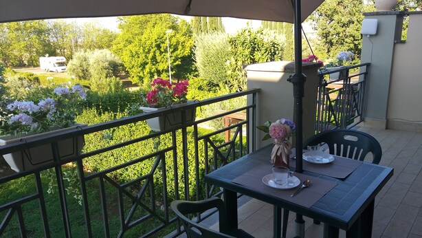 Eine Außenpatio mit einem für zwei Personen gedeckten Tisch, umgeben von einem Metallgeländer.