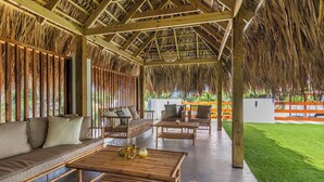 A covered outdoor seating area with wooden furniture and a thatched roof. - Villa Blou, steps from Jan Thiel Beach (Jan Thiel)