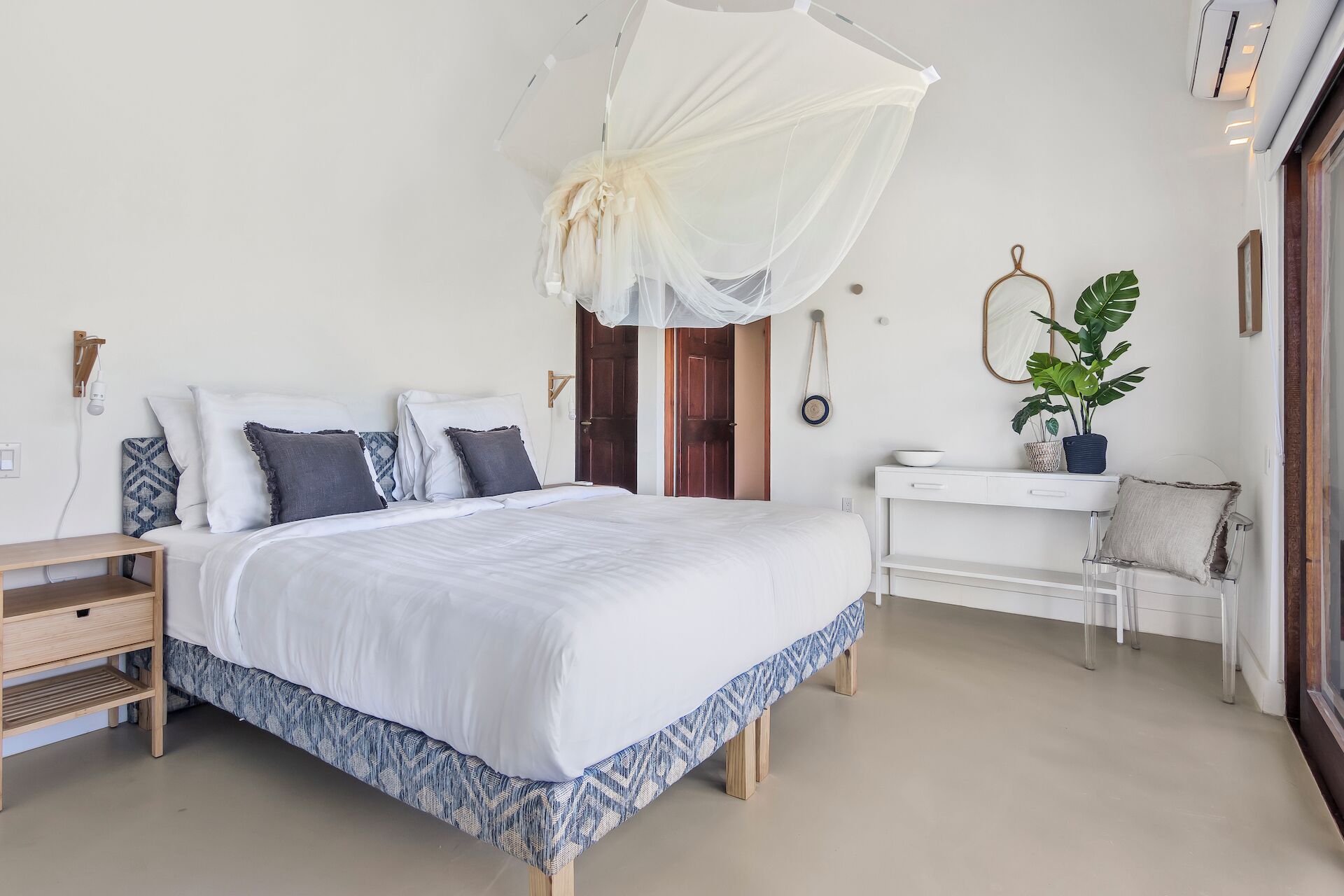 Un dormitorio con cama, mesita de noche y velador.