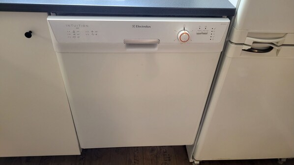 Un lave-vaisselle blanc doté d’un panneau de commande marqué du nom « Electrolux » et d’un cadran de réglage de la température.
