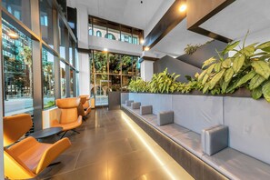 Relax in a stylish seating area with comfortable chairs and a long bench, offering views of the surrounding area.