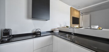 Una cucina moderna con un piano di lavoro nero, lavello in acciaio inossidabile e mobili bianchi.