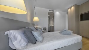 Une chambre moderne avec un grand lit, des tables de chevet, un bureau et une chaise.