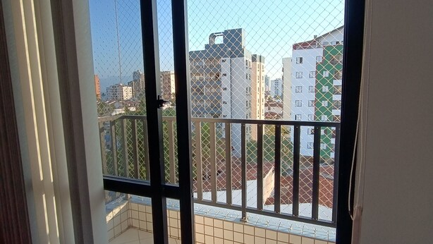 Vista desde un balcón con barandilla de metal, suelo de baldosas y cielo despejado.