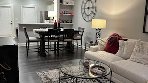 A modern living room with a sofa, coffee table, and dining area. - Georgia Dawg House! Game weekend, business travel, this condo has it all!  (Athens)