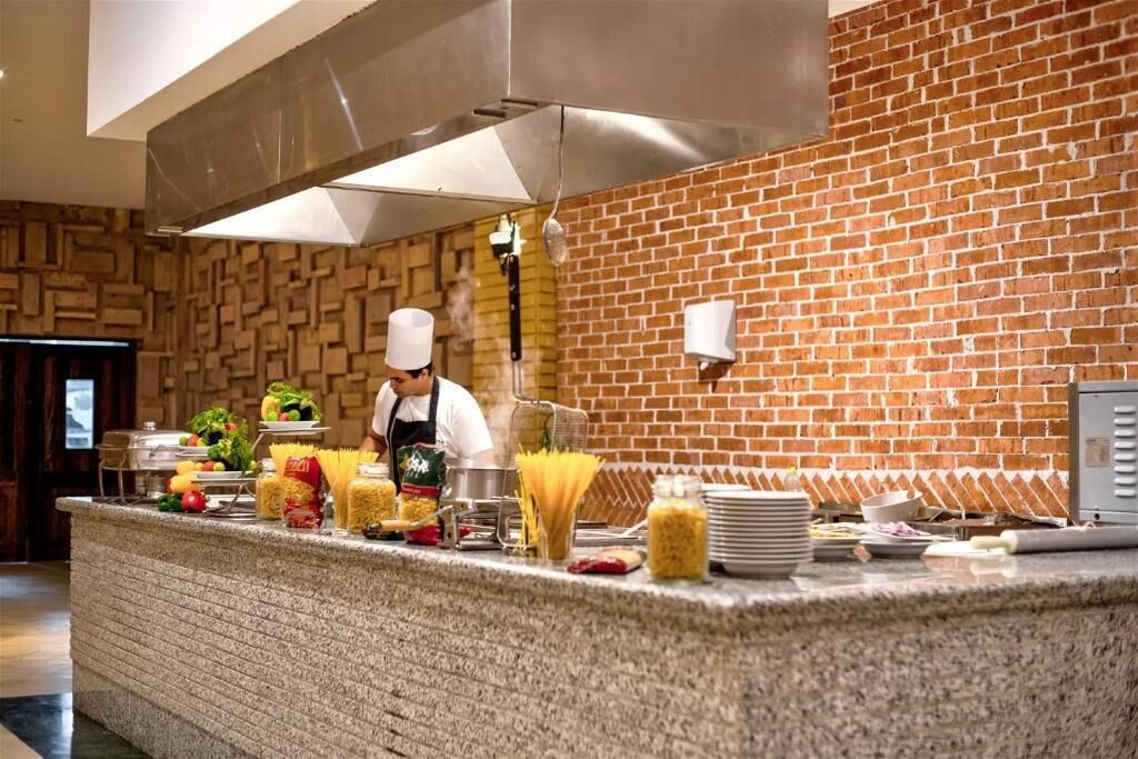 Una encimera de cocina con pasta, verduras y utensilios de cocina.