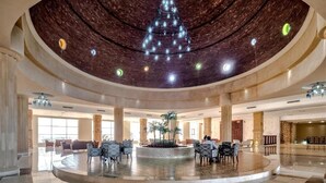 A spacious lobby with a central fountain, seating areas, and a high ceiling with a decorative light fixture. - Amarina Queen Resort & Aqua Park Marsa Alam (Marsa Alam)