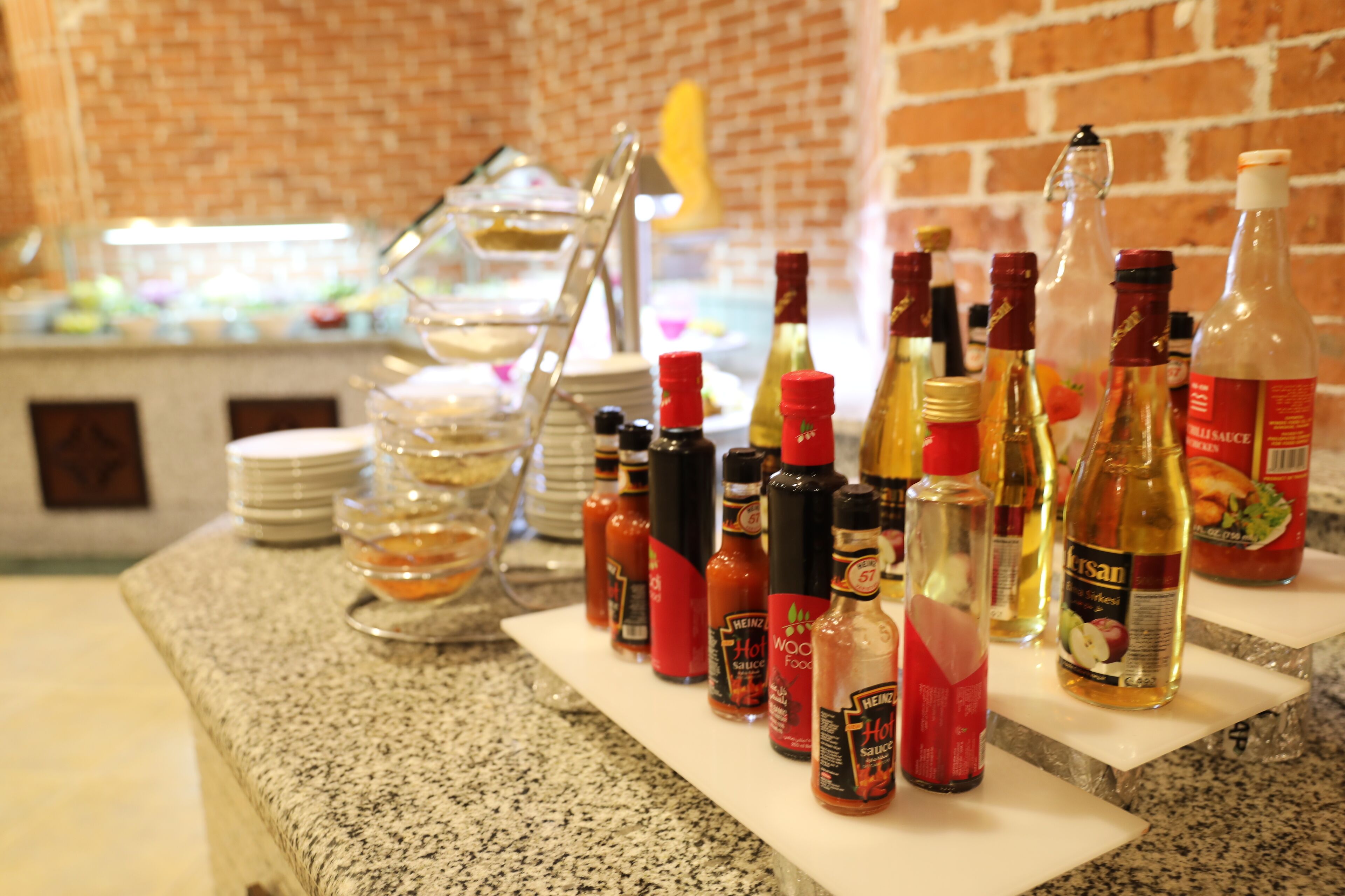 A kitchen counter with various condiments and a stack of plates.