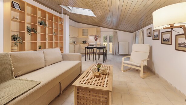 Amplia sala de estar con techo de madera, un sofá, una mesa de centro y una silla. Cuenta con una zona de cocina con armarios y una mesa de comedor.