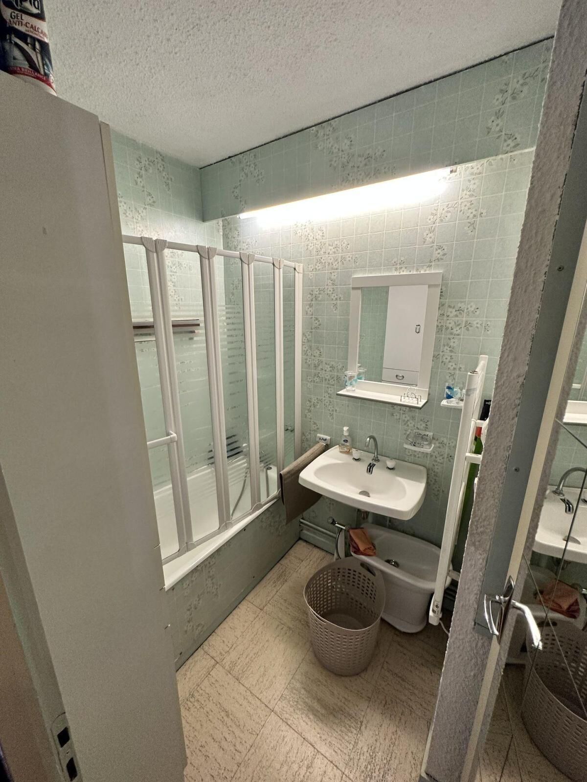 A bathroom with a shower, a sink, and a mirror.