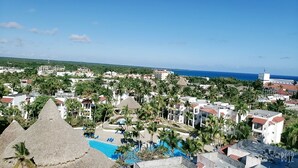 A resort with a swimming pool, palm trees, and a view of the ocean. - Hotel boca del mar Bocachica playa   (Boca Chica)