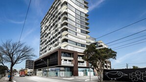 A modern high-rise building with multiple balconies and large windows.