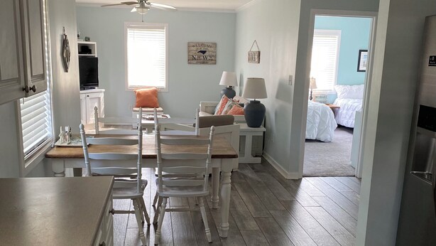 A spacious living area with a dining table, chairs, and a kitchen area with a refrigerator. - 3 blocks from Taylors Creek, 1 mile from Beaufort waterfront and boat ramp (Beaufort)