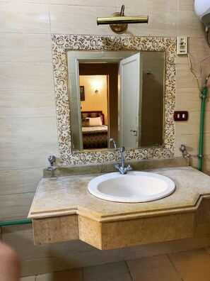 A bathroom with a white sink, a mirror, and a shower. - Egypt (Giza)