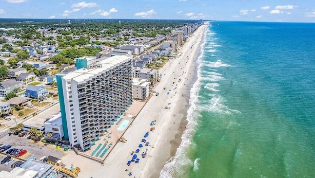 A coastal hotel with a long beachfront, a pool area, and a parking lot. - Cozy 2BR/2BA Oceanfront Condo - Steps from the Beach! (Murrells Inlet)