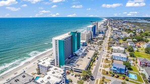 A coastal hotel with multiple buildings, a beach, and a clear view of the ocean. - Cozy 2BR/2BA Oceanfront Condo - Steps from the Beach! (Murrells Inlet)