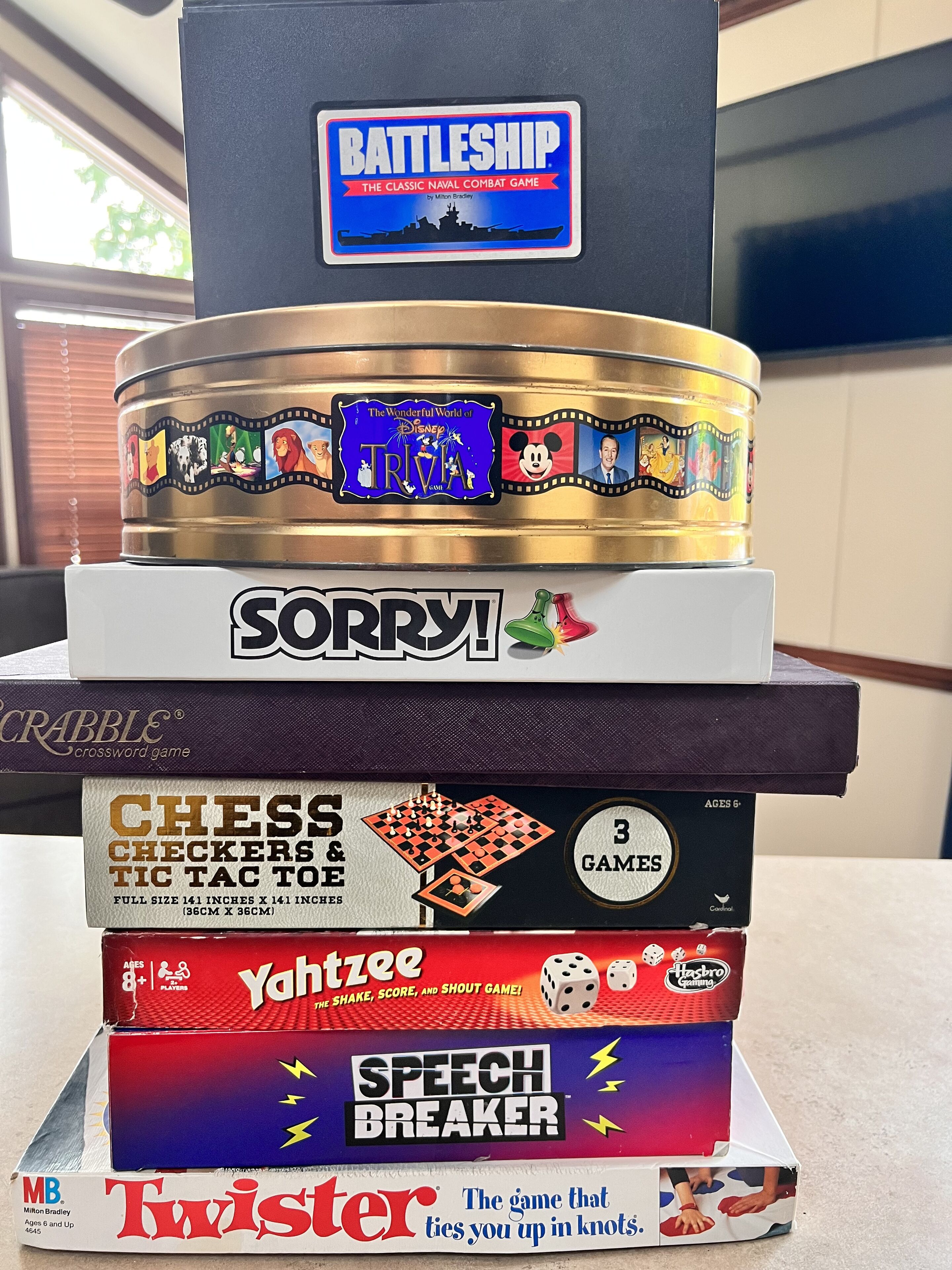 A stack of board games including Battleship, Sorry!, and others.