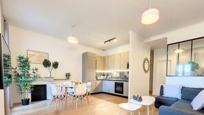 A modern living room with a sofa, a dining table with chairs, and a kitchen area with cabinets and appliances. - N&J - MADAGASCAR - Central - Very close sea (Niza)