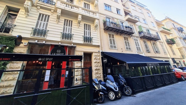 A multi-story building with a restaurant named "Le Spot" on the ground floor, featuring a black awning and a sign for "Art & Burgers." - N&J - TERRACOTTA- Central - Proche mer (Niza)