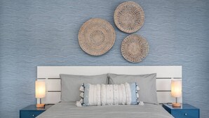 Una camera da letto con un letto, due comodini e tre decorazioni circolari intrecciate appese al muro.