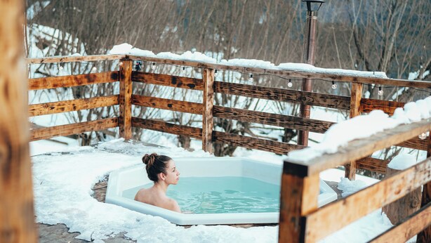 A wooden deck with a hot tub surrounded by snow. - Transylvanian Tiny House Apuseni Mountains. (Mătișești, Comuna Horea)