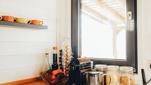 A kitchen counter with various items including a coffee maker, jars, and a fruit bowl. - Transylvanian Tiny House Apuseni Mountains. (Mătișești, Comuna Horea)
