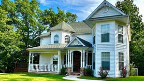 A two-story house with a porch, a stone entrance, and a well-maintained lawn. - The Victorian @ Lake Cumberland - Beaver Creek, firepit, sleeps 18 (Monticello)