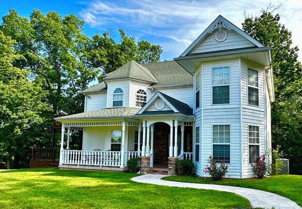 A two-story house with a porch, a stone entrance, and a well-maintained lawn. - The Victorian @ Lake Cumberland - Beaver Creek, firepit, sleeps 18 (Monticello)