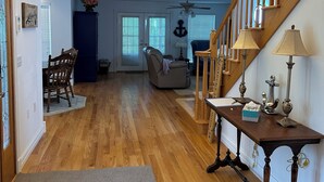 A spacious living room with hardwood floors, a dining area, and a staircase. - The Victorian @ Lake Cumberland - Beaver Creek, firepit, sleeps 18 (Monticello)