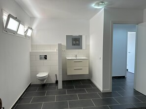 Een douche, handdoeken, toiletpapier