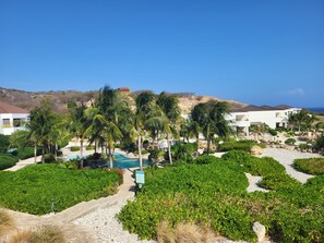 Un resort con piscina, palmeras y vista al océano.