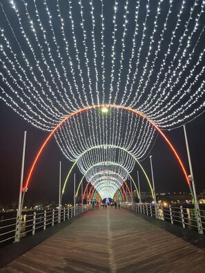 Eine Fußgängerbrücke mit einer Reihe von Lichtern, die einen Tunnellichteffekt erzeugen.