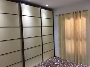 A room with a bed, a sliding door, and a curtain.
