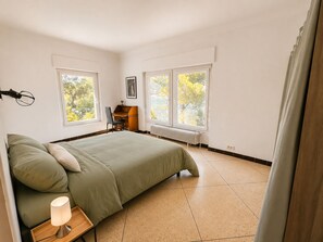 Una camera da letto con un letto, una scrivania e due finestre.