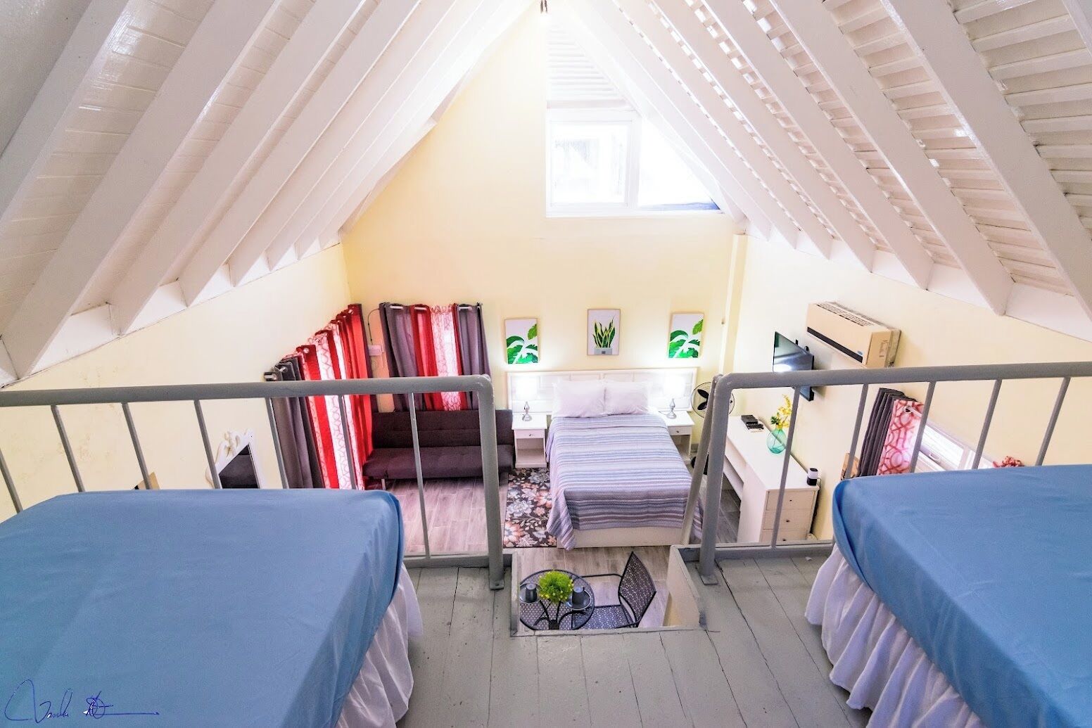 Een slaapzaal met twee bedden, een bureau, een stoel en een raam.