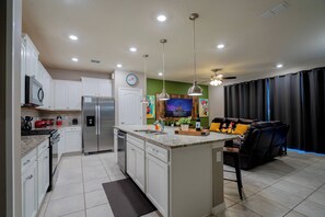 Enjoy cooking in this well-equipped kitchen with a central island, sink, and stainless steel appliances.