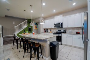 Enjoy cooking in this well-equipped kitchen with a large island, sink, and ample counter space.