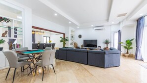 A modern living room with a pool table, a large sofa, and a television. - 30Pax 5BR Luxurious 57ft Pool KL  (Kuala Lumpur)