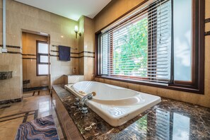 A modern bathroom with a large bathtub, marble flooring, and a window with blinds. - 30Pax 5BR Luxurious 57ft Pool KL  (Kuala Lumpur)