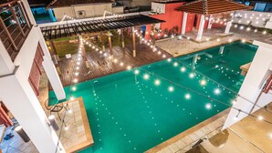 A rooftop swimming pool with string lights, a covered seating area, and a view of the surrounding buildings. - 30Pax 5BR Luxurious 57ft Pool KL  (Kuala Lumpur)
